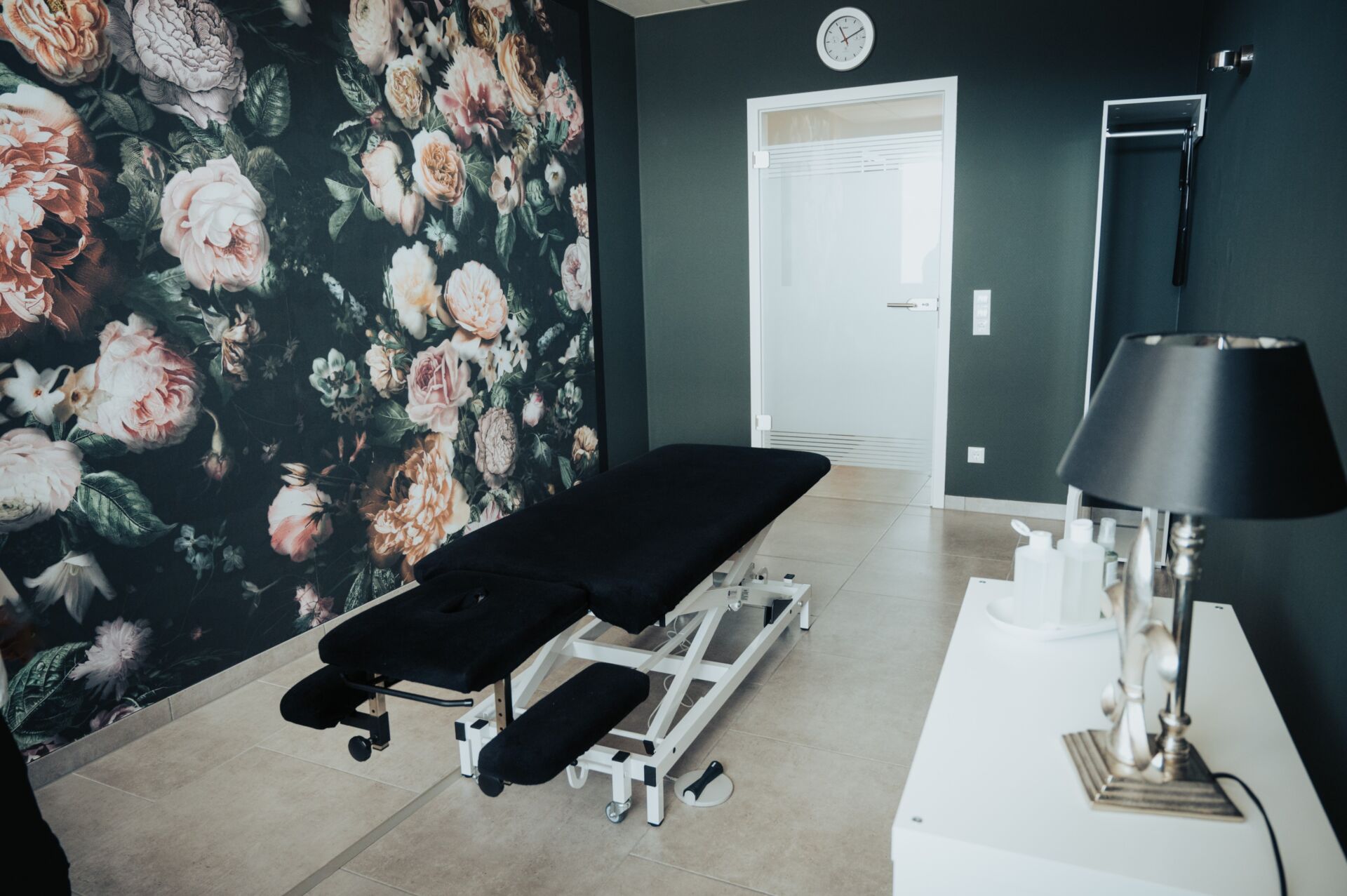 Schwarze Massageliege mit Blick zur Tür in einem Behandlungsraum der Physiotherapie Pfundstein