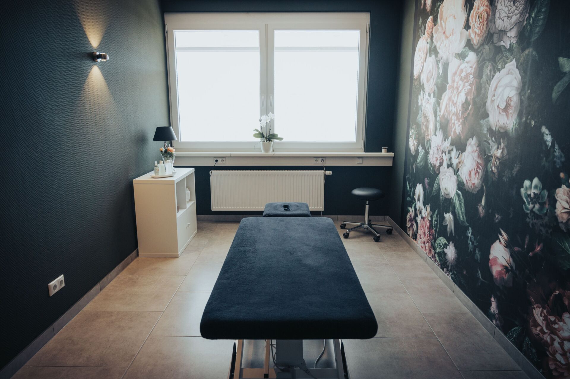 Schwarze Massageliege in einem Behandlungsraum der Physiotherapie Pfundstein