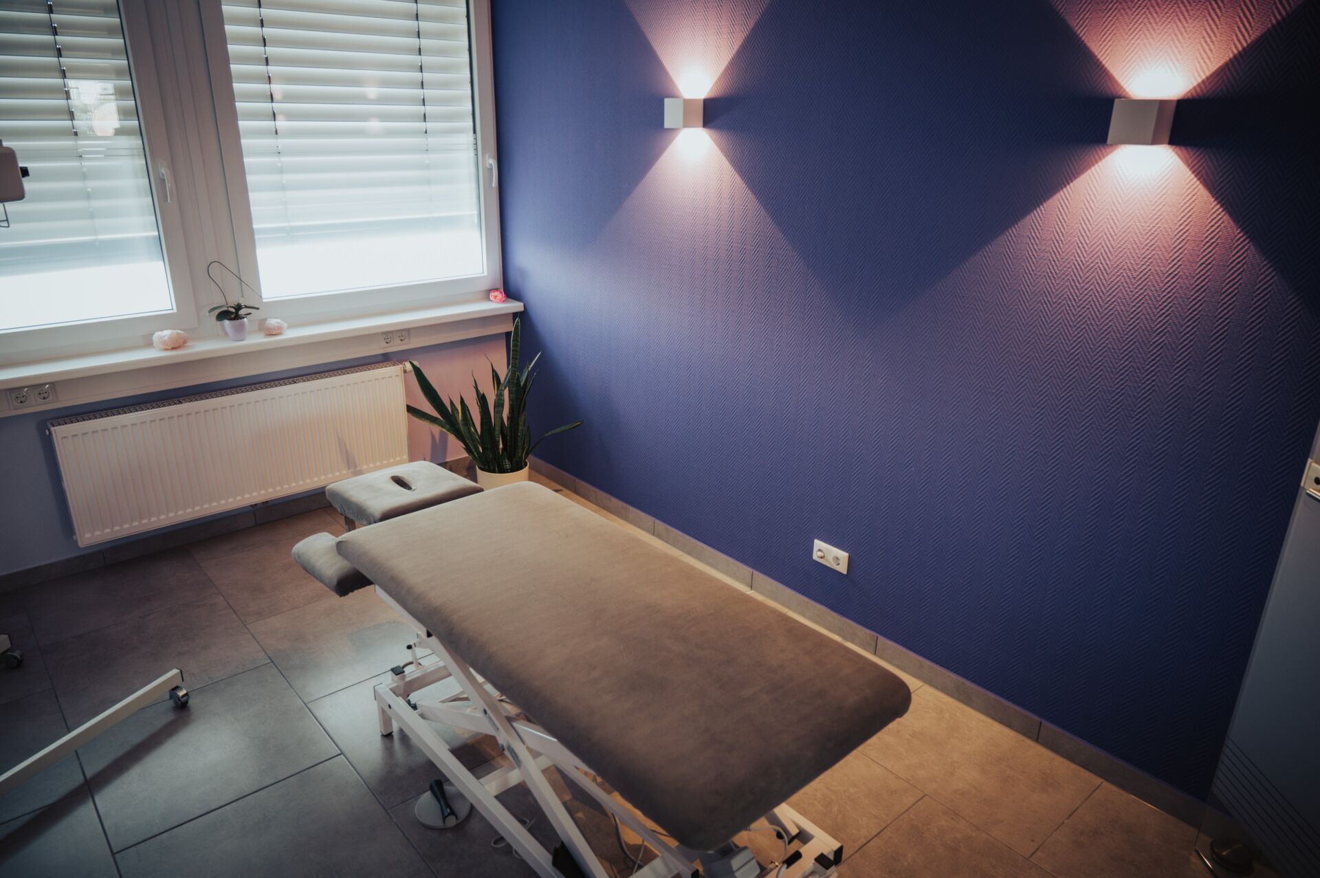 Graue Massageliege in einem Behandlungsraum der Physiotherapie Pfundstein