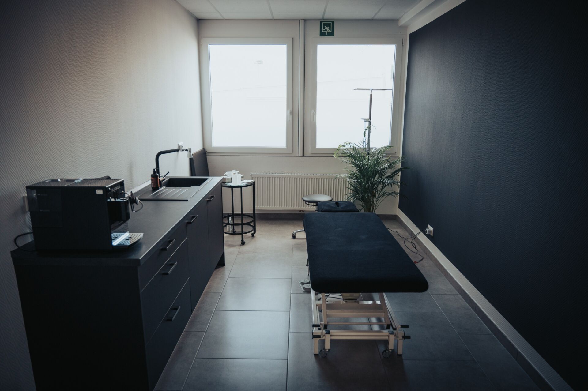 Schwarze Massageliege in einem Behandlungsraum der Physiotherapie Pfundstein